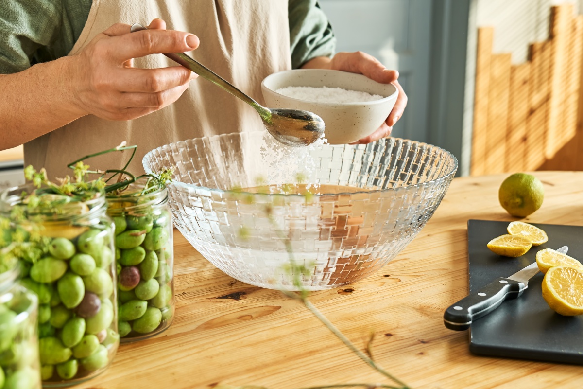 Salz rieselt in eine Schüssel mit Wasser.