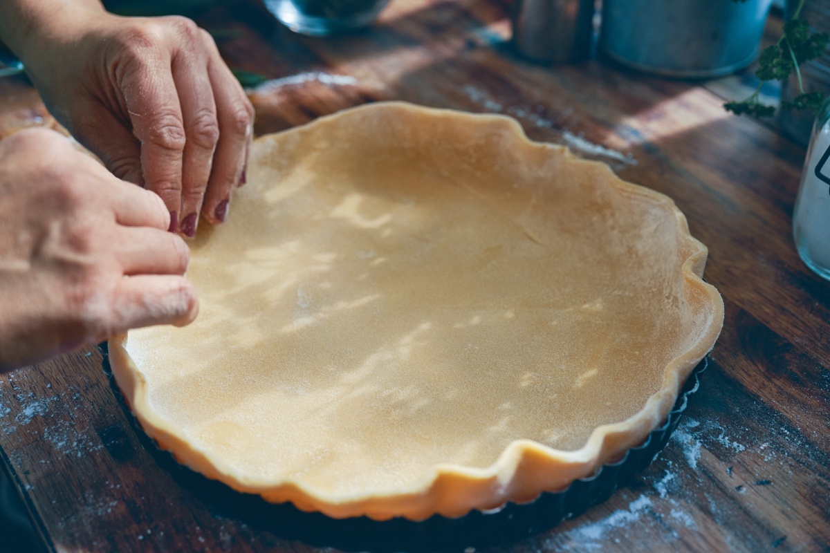 Der Teig für den Quiche-Boden wird in die Form gedrückt