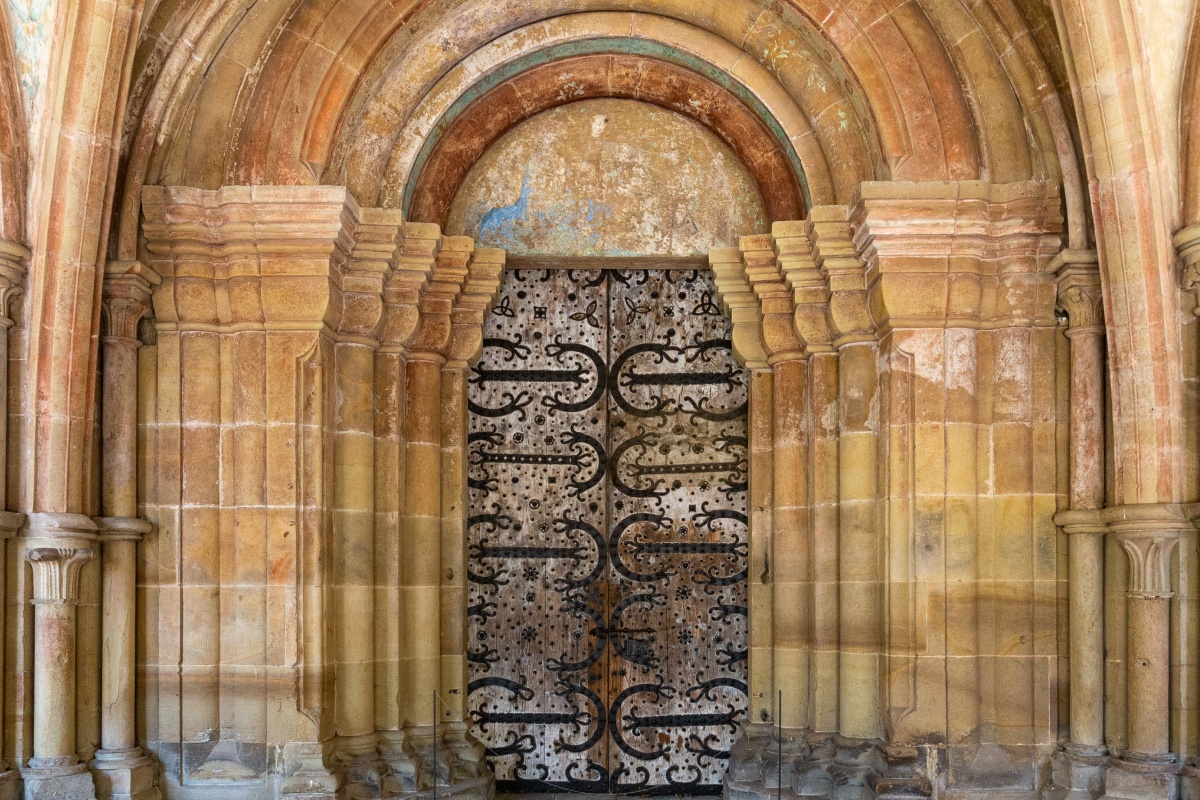 Gotisches Tor von Kloster Maulbronn mit verzierten Eisenbeschlägen und sandsteinfarbenen Bögen.