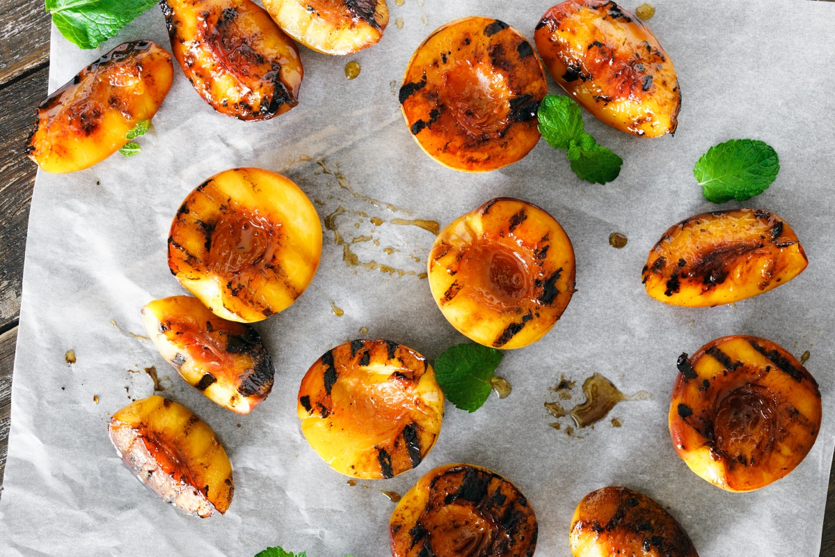 Geröstete Pfirsiche liegen auf Backpapier.