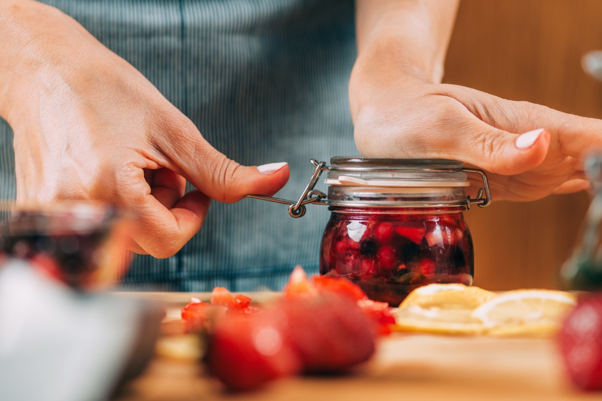 Hände verschließen ein Einmachglas.