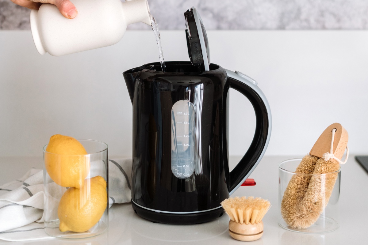 Ein Person füllt Zitronensaft in einen Wasserkocher