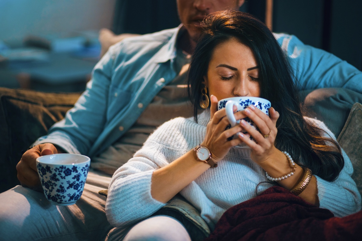 Frau nippt genussvoll an einer großen Tasse Tee