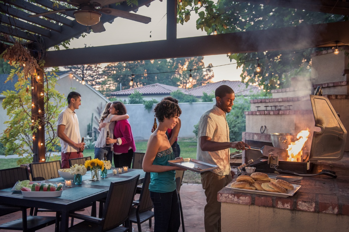 Eine Gruppe von Freunden bei einem Grillend mit Outdoorküche.