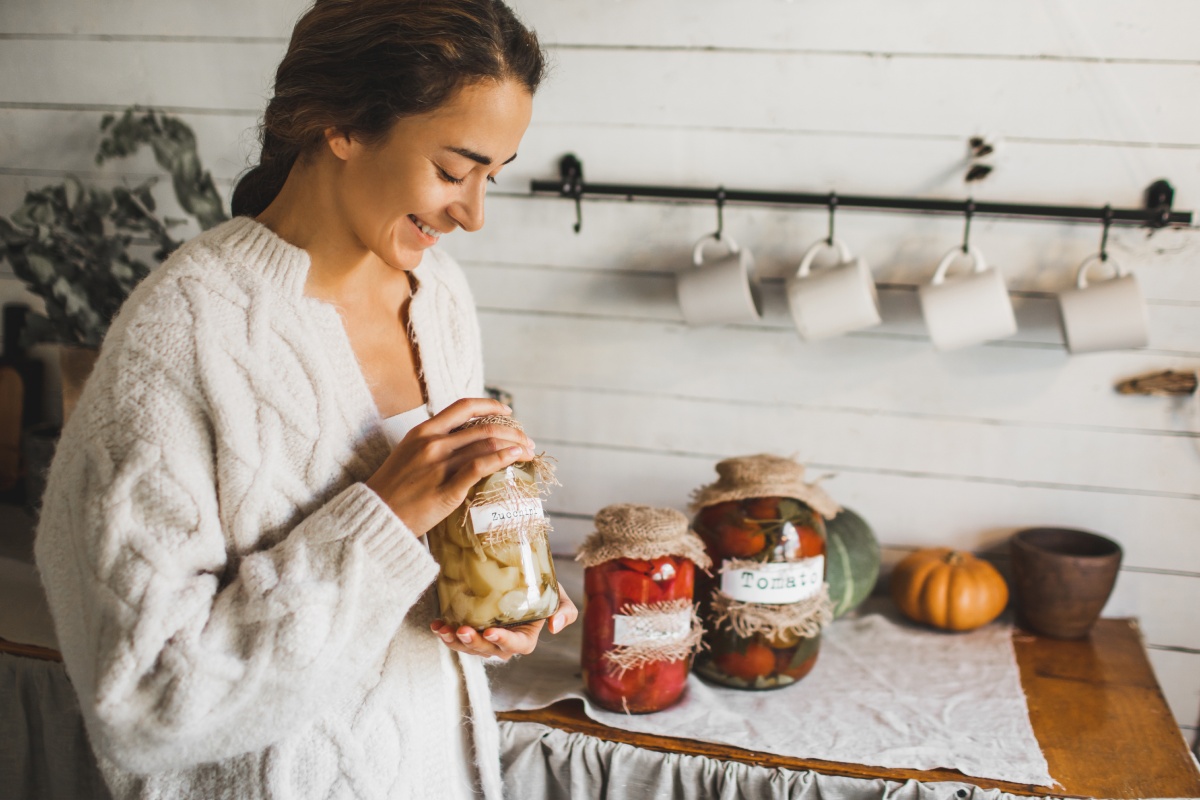 Frau mit Einmachgläsern mit fermentiertem Gemüse.