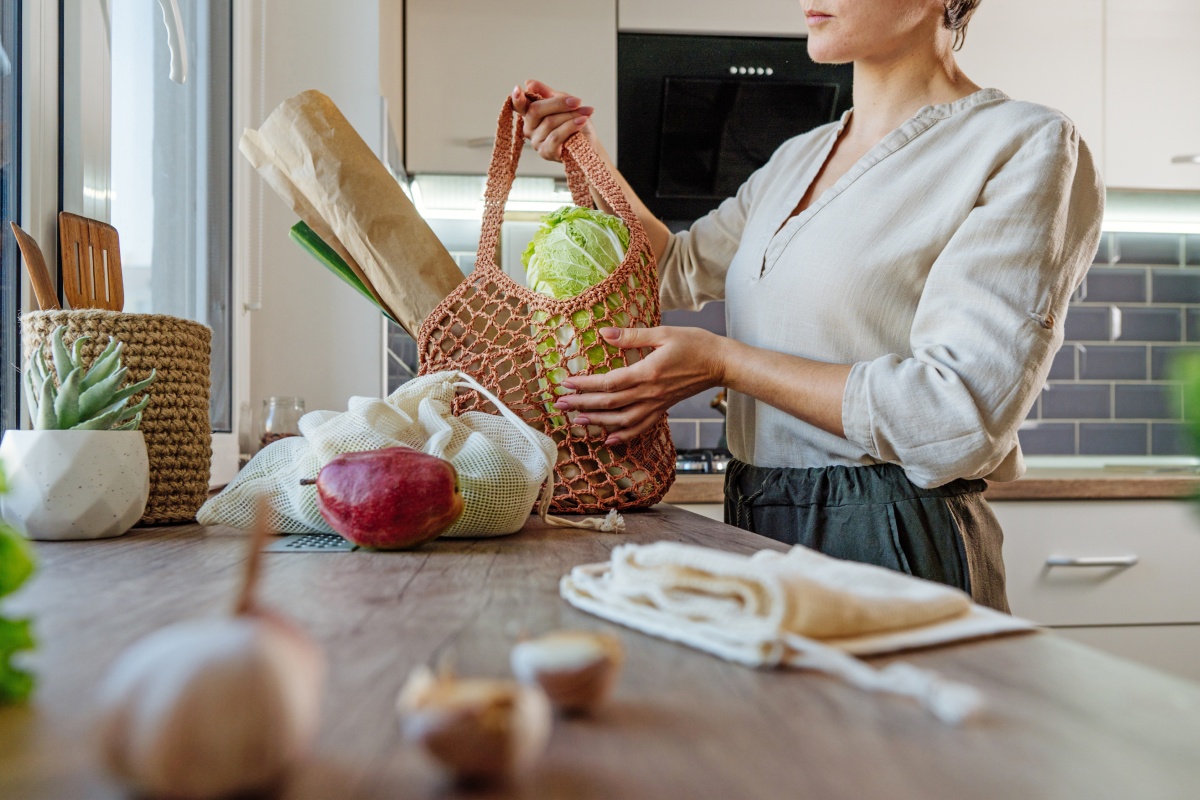 Eine Frau hält eine Tasche, gefüllt mit Gemüse.