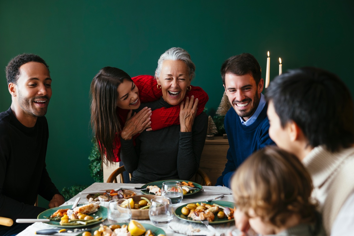 Eine Familie sitzt an einem festlich gedeckten Tisch zu Weihnachten.