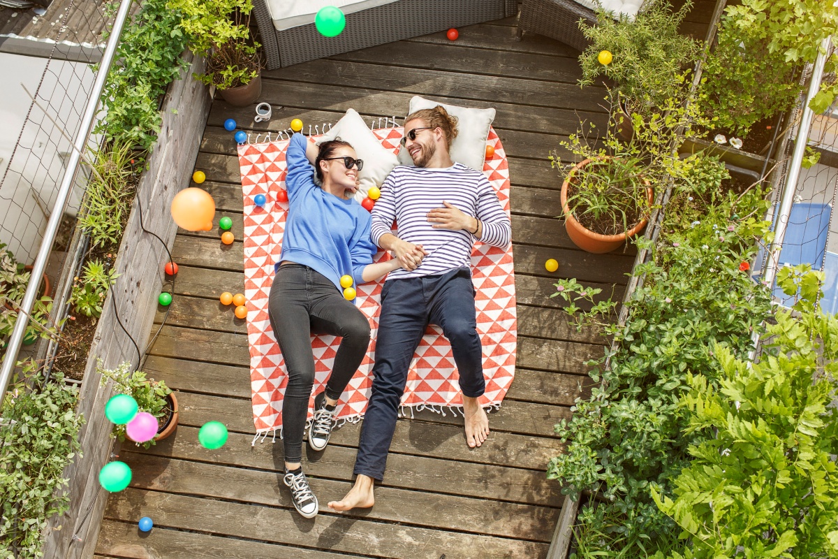 Ein Paar liegt auf ihrer sonnigen Terrasse und macht Urlaub zu Hause