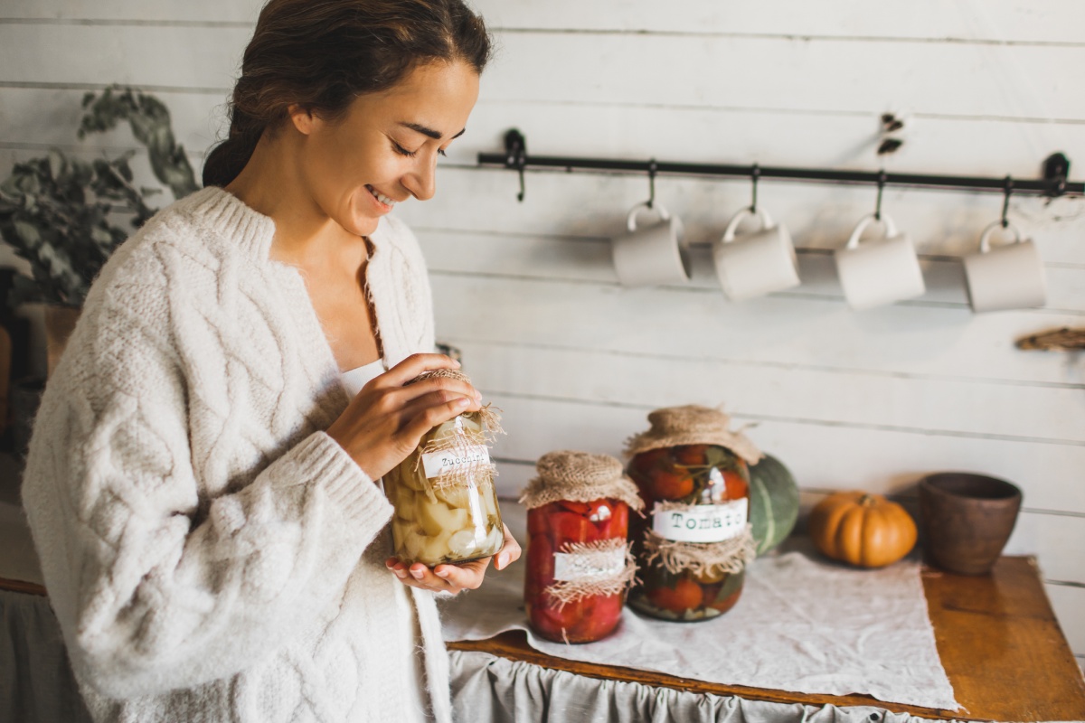 Frau mit Einmachgläsern mit fermentiertem Gemüse.