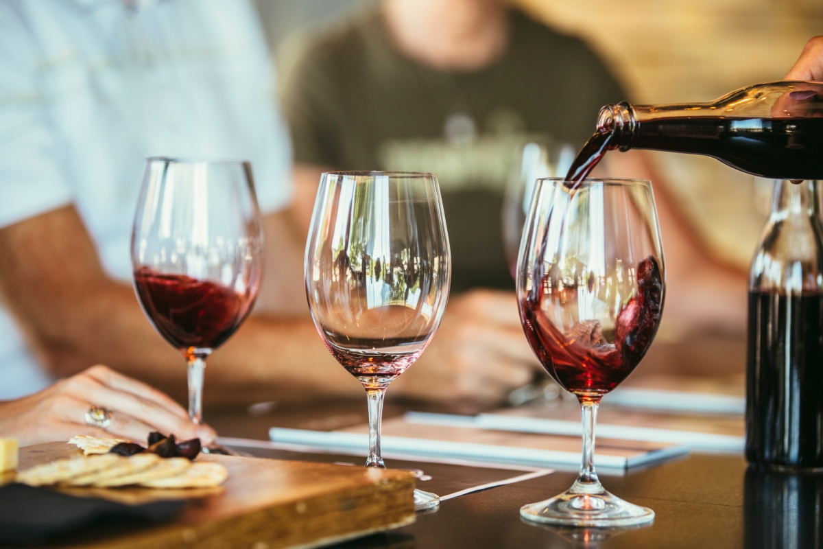 Rotwein wird in ein Weinglas bei einem festlichen Abendessen eingeschenkt.