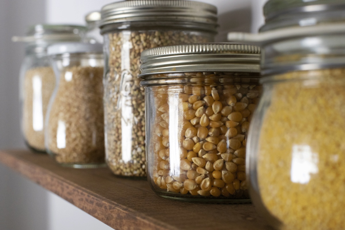 Ein Regalbrett mit trockenen Lebensmitteln in Gläser.