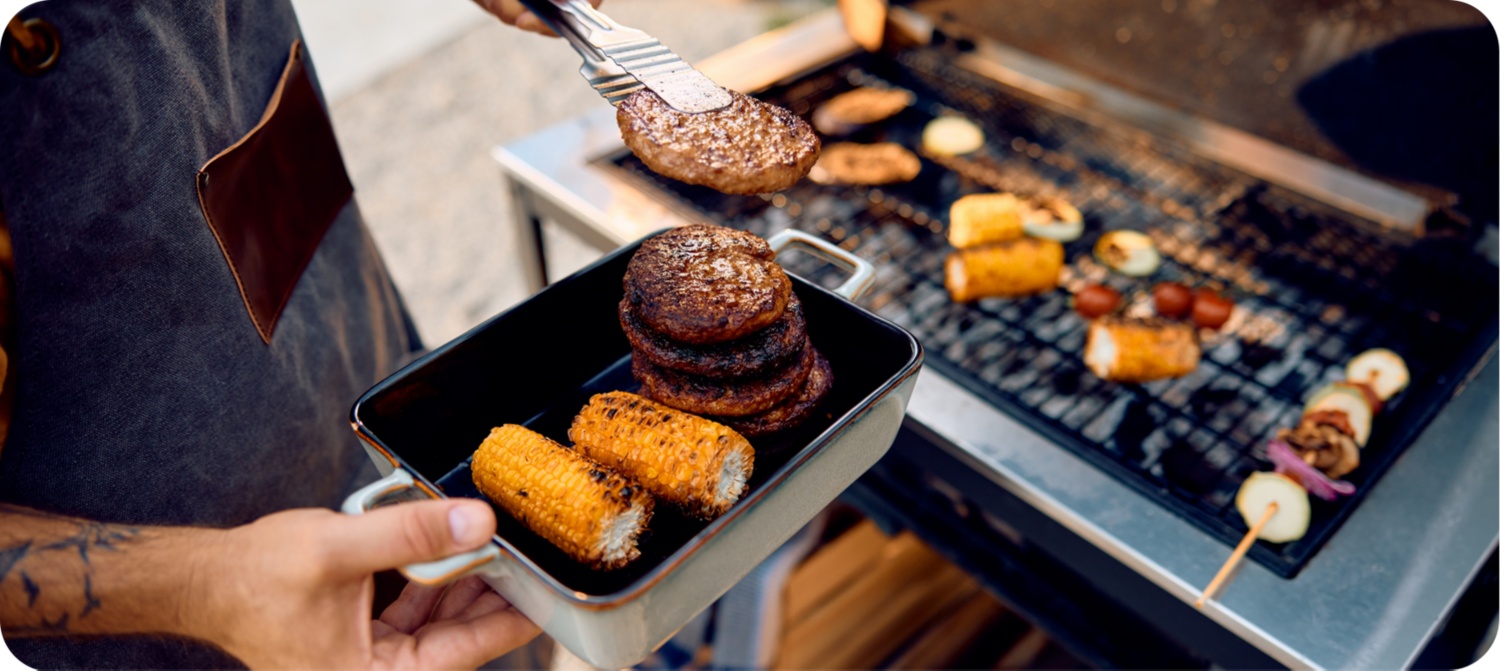 Detailbild eines Grilltellers in der Hand des Grillenden.