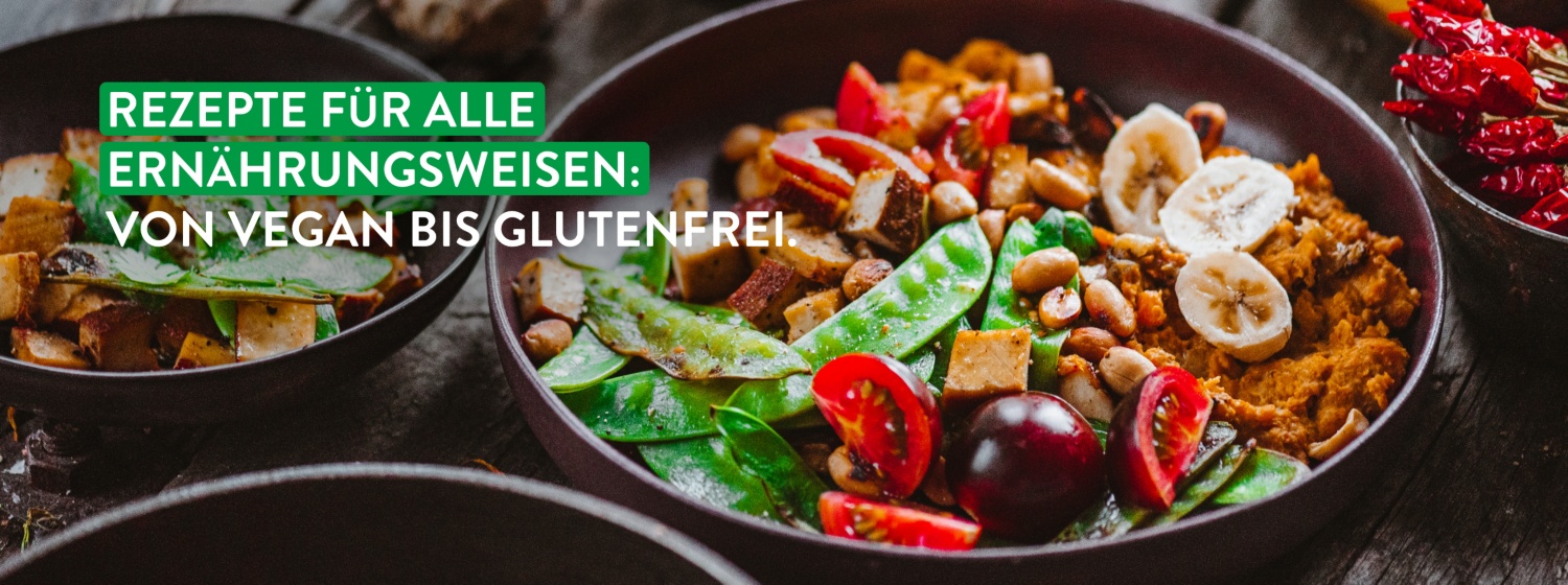Vegane Buddha-Bowl mit Zuckerschoten, Tomaten, Bananenscheiben, Tofu und Nüssen in einer braunen Schale, rustikal serviert.
