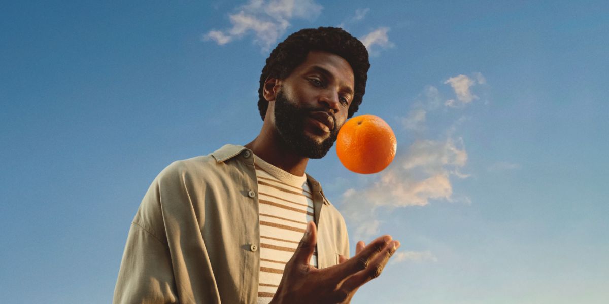 Auf einem Weizenfeld blühen ein paar Blumen zwischen den Halmen.