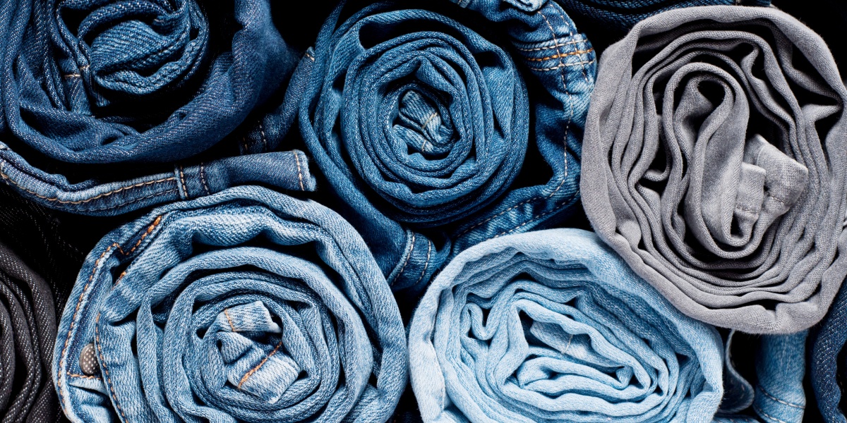 Aufgerollte Jeans liegen aufeinandergestapelt.
