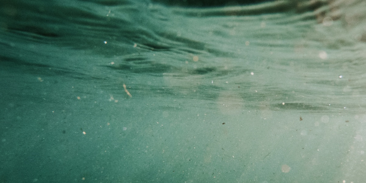 Unterwasseraufnahme von Plasikpartikeln im Meer.