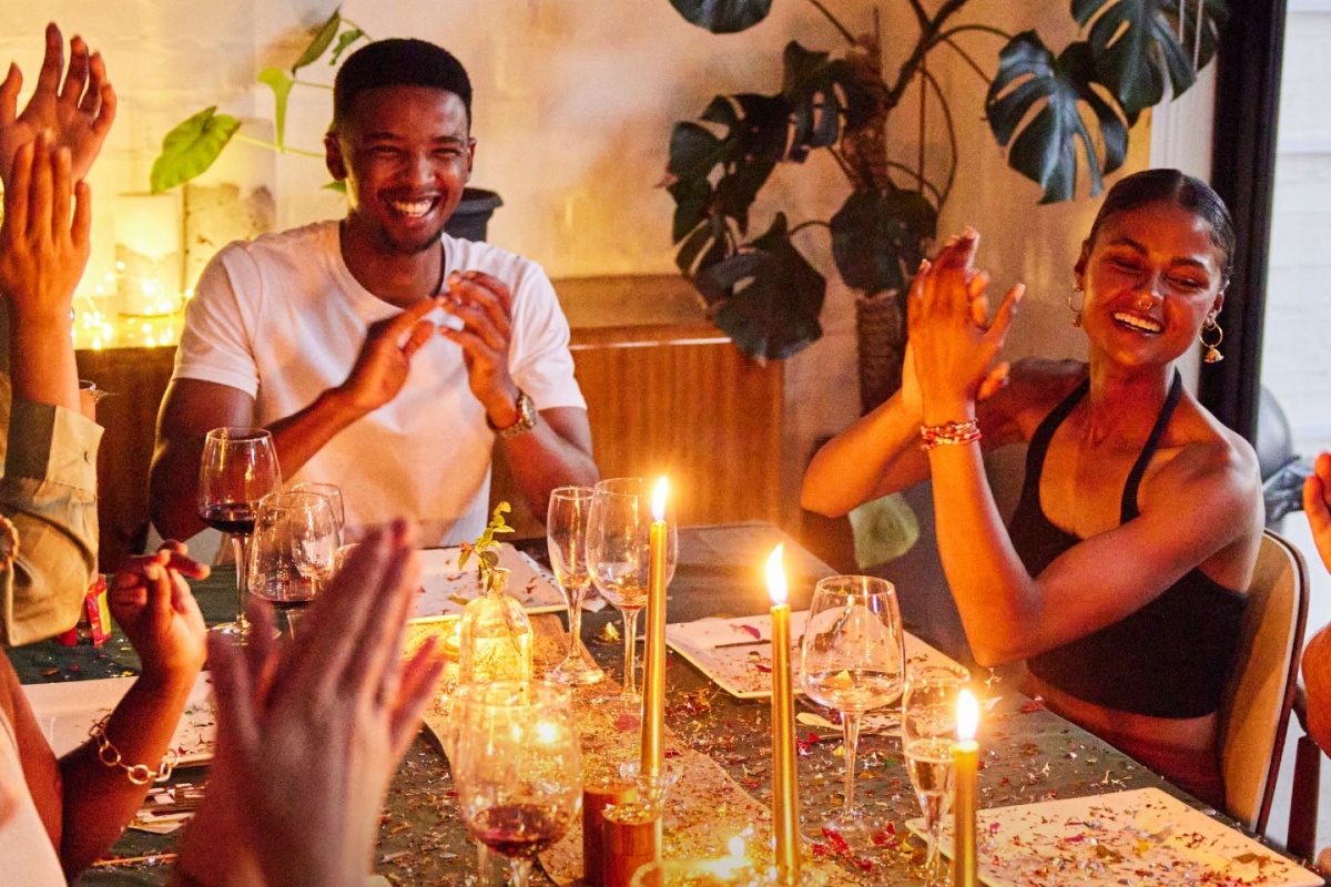 Freunde sitzen gemeinsam zu Silvester am Tisch.