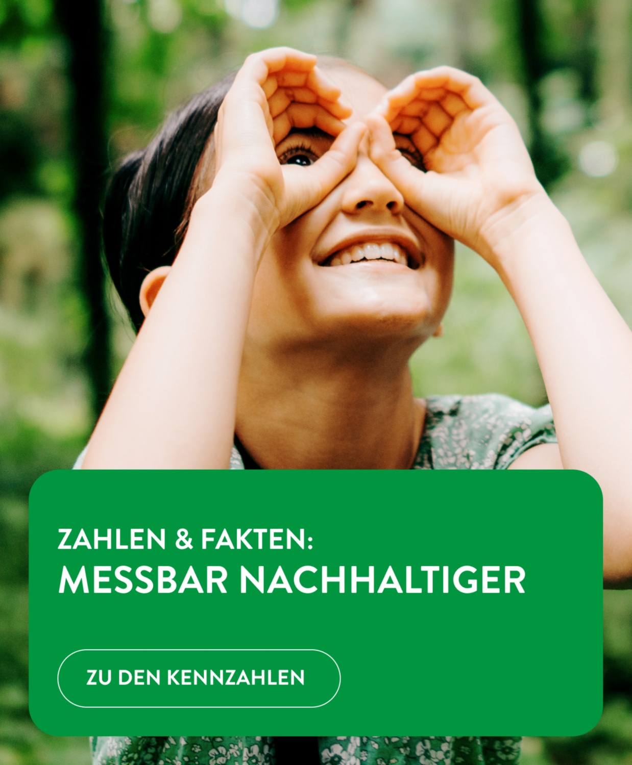 Ein Kind hält seine Hände wie ein Fernglas vor die Augen und betrachtet die Bäume im Wald.