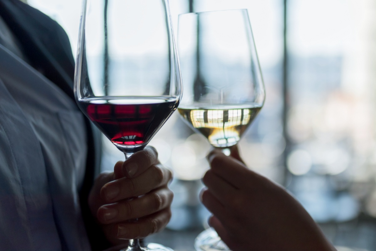 Nahaufnahme von zwei Weingläsern, eines mit Rotwein, das andere mit Weißwein gefüllt.