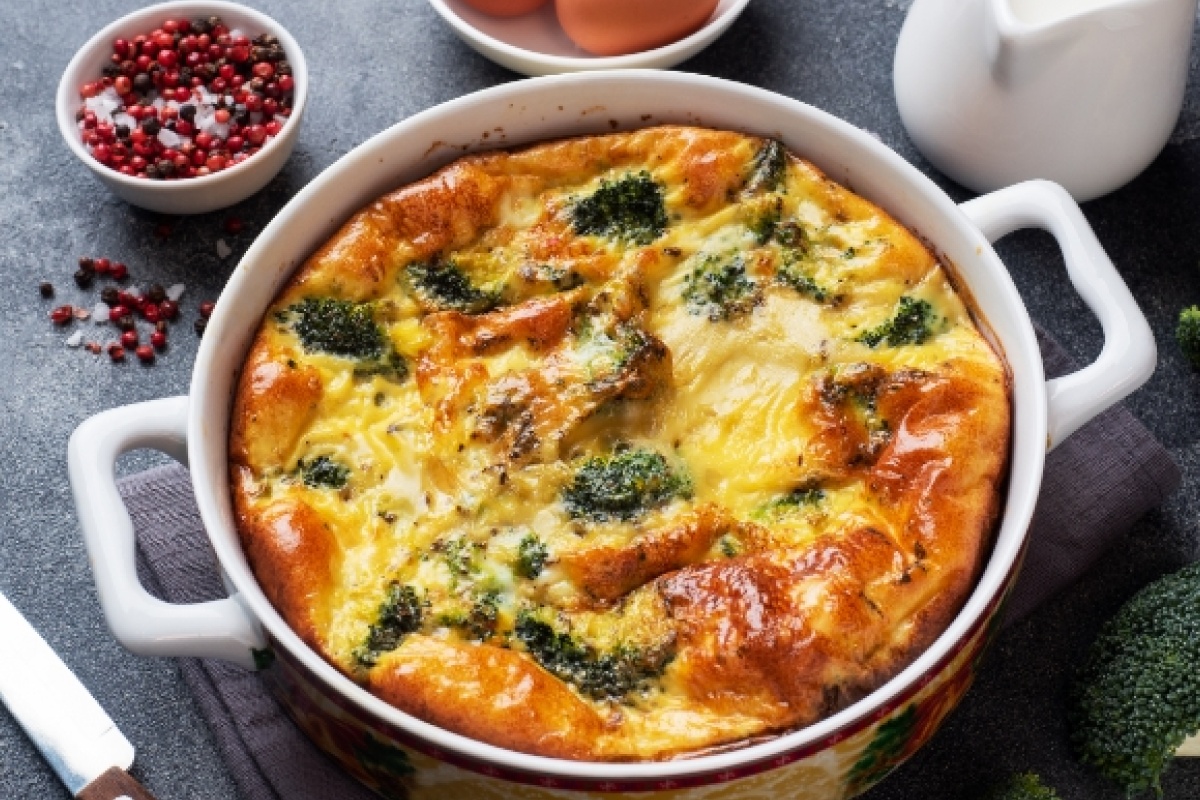 Ofenfrische Brokkoli-Quiche in einer weißen Auflaufform.