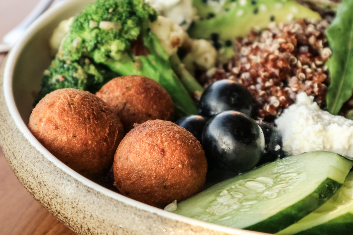 Nahaufnahme einer vegetarischen Bowl mit Gemüse und Falafeln.