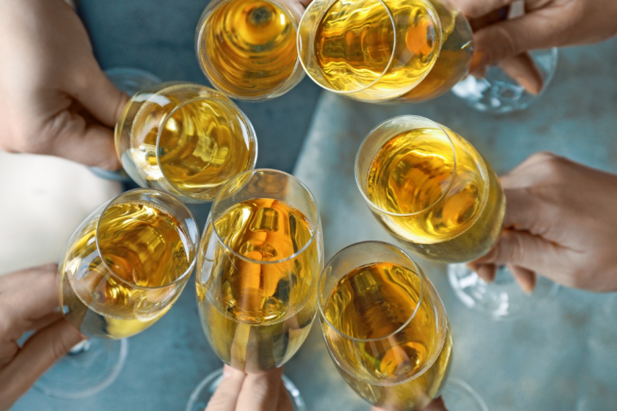 Mehrere Hände stoßen mit gefüllten Sektgläsern an.