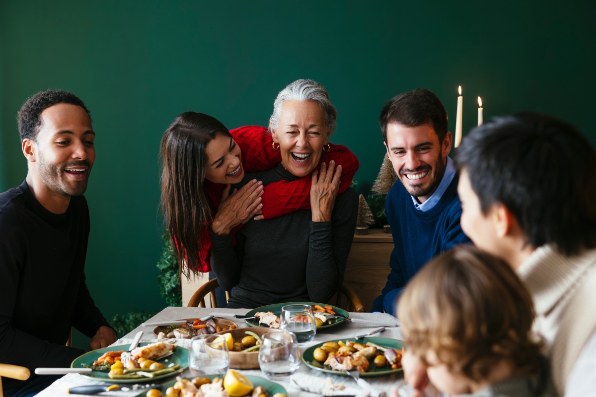 Eine Familie sitzt an einem festlich gedeckten Tisch zu Weihnachten.
