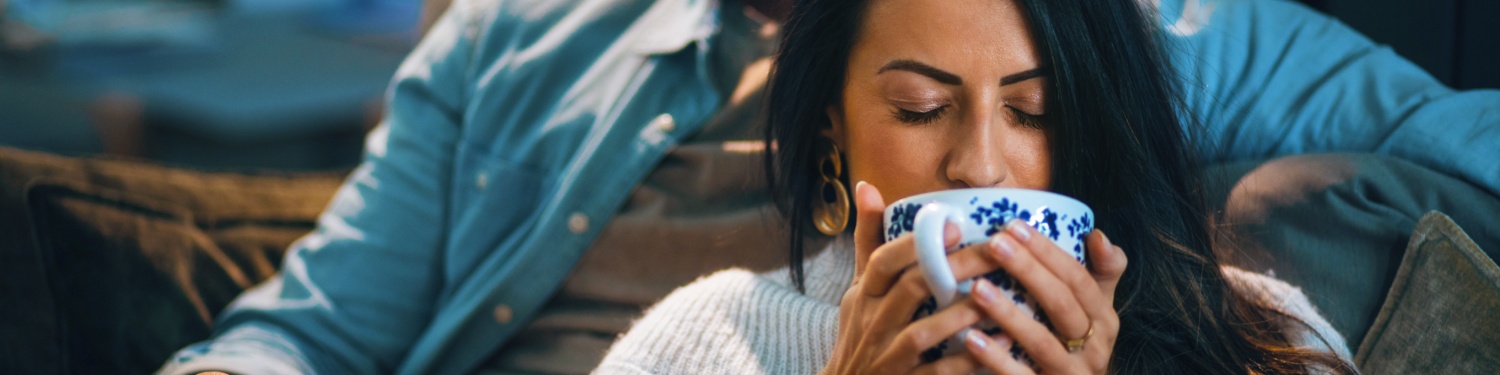 Frau nippt genussvoll an einer großen Tasse Tee