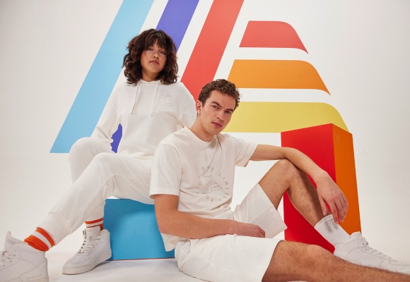 Eine Frau und einn Mann tragen weiße Shirts, Shorts, Jogginghosen und Hoodie-Pullover der neuen ALDImania Pure Collektion.
