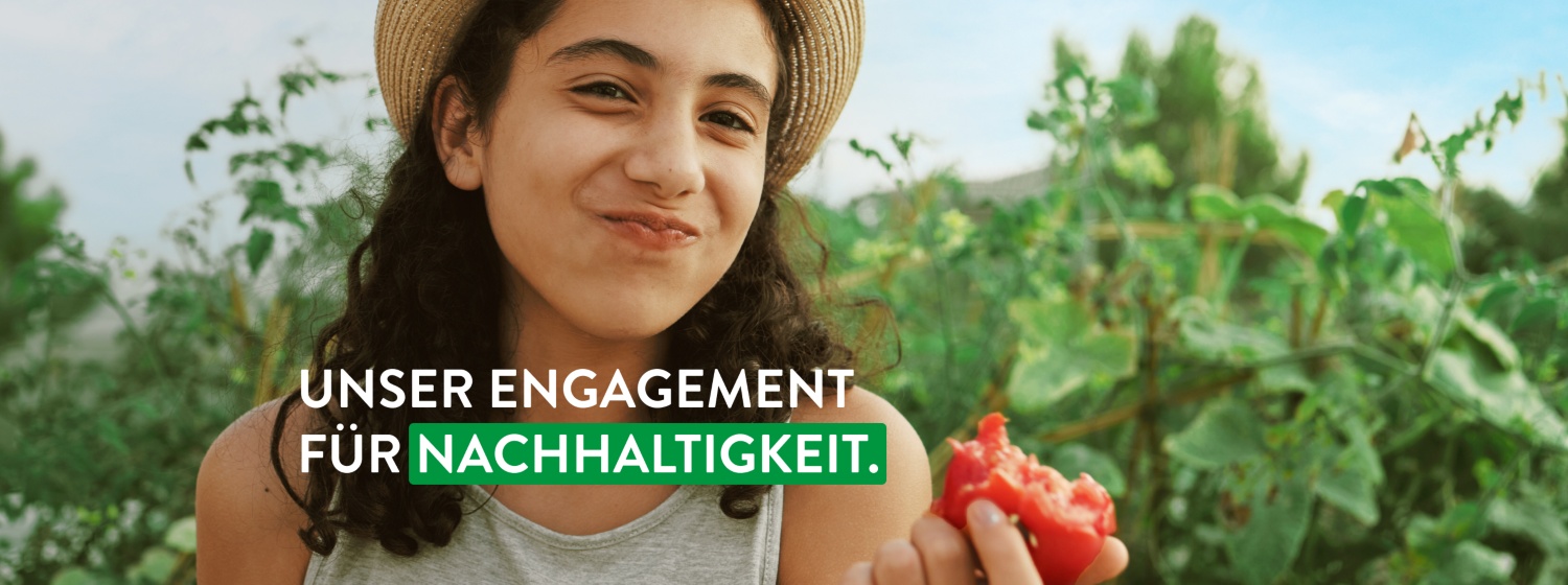 Kind steht in Feld und beißt in frisches Obst