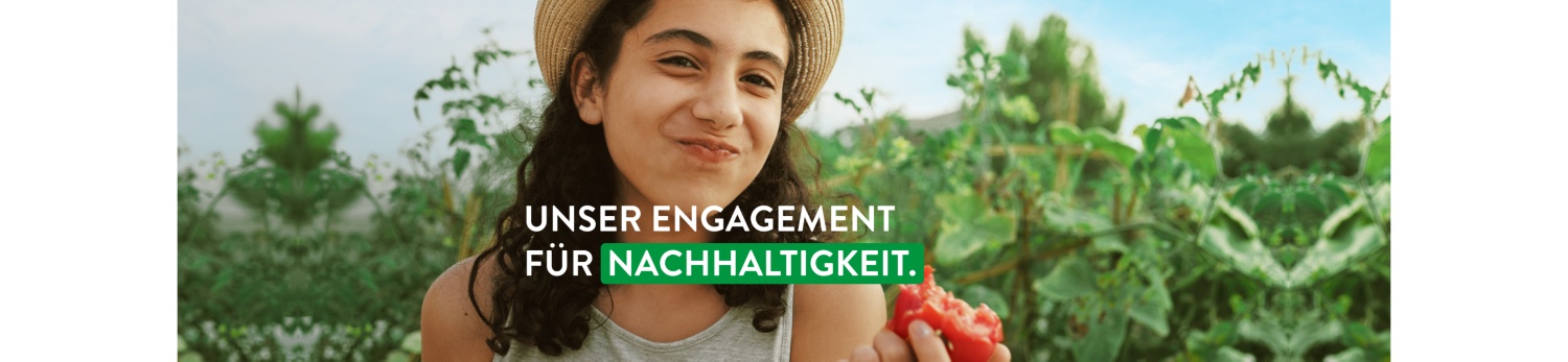 Kind steht in Feld und beißt in frisches Obst.