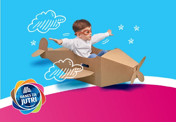 Deček z letalskimi očali v kartonskem letalu