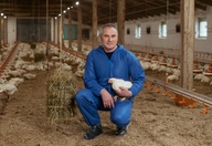 Moški v hlevu s piščanci