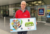 Moški na sliki drži darilni bon