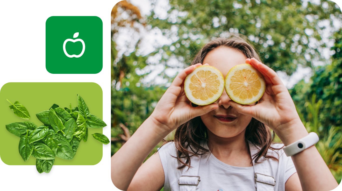 Ein junges Mädchen hält sich zwei Zitronenhälften als Brille vor die Augen