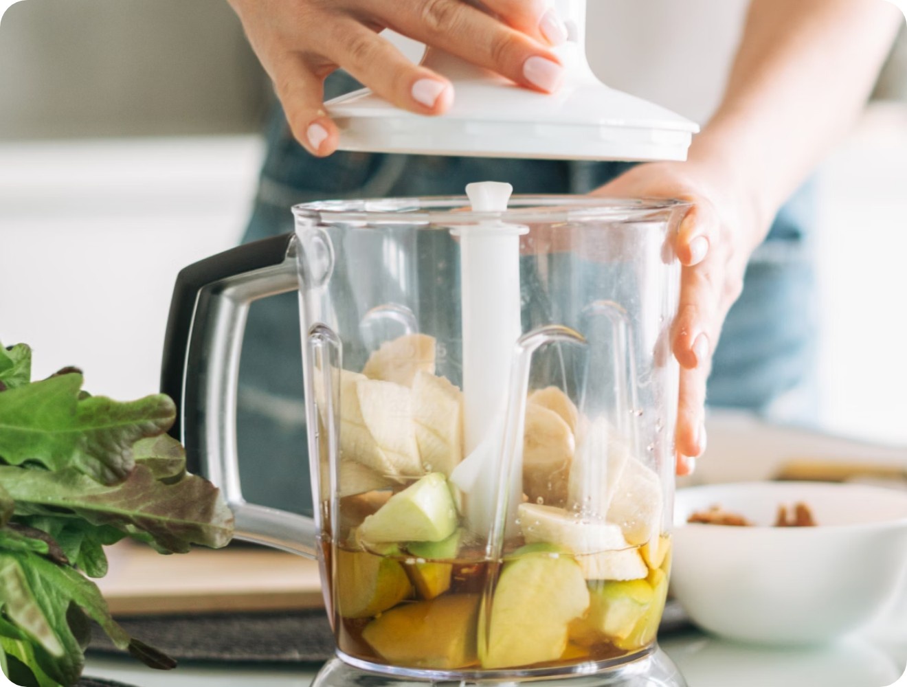 Eine Person bereitet sich einen Saft mit Obst zu.