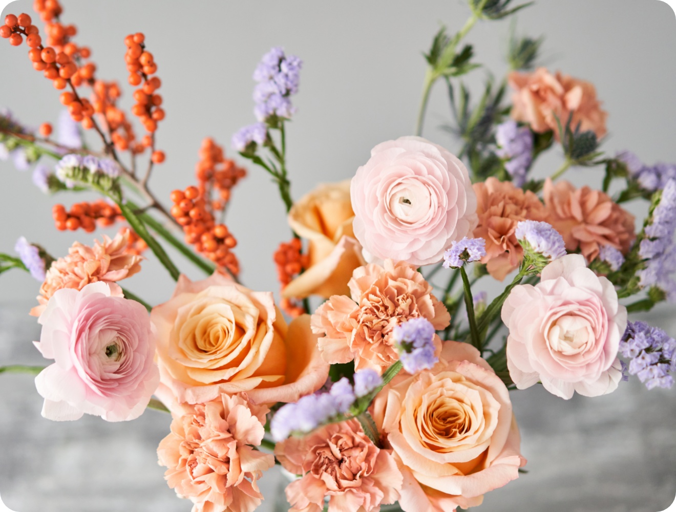 Frischer Blumenstrauß in der Vase mit rosa und aprikotfarbenen Blumen.