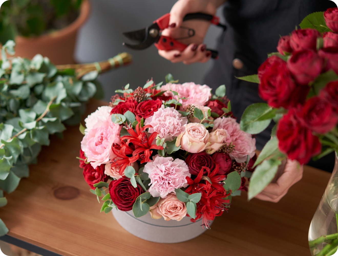 Fertig gestecktes Blumenarrangement aus rosa und roten Blumen.