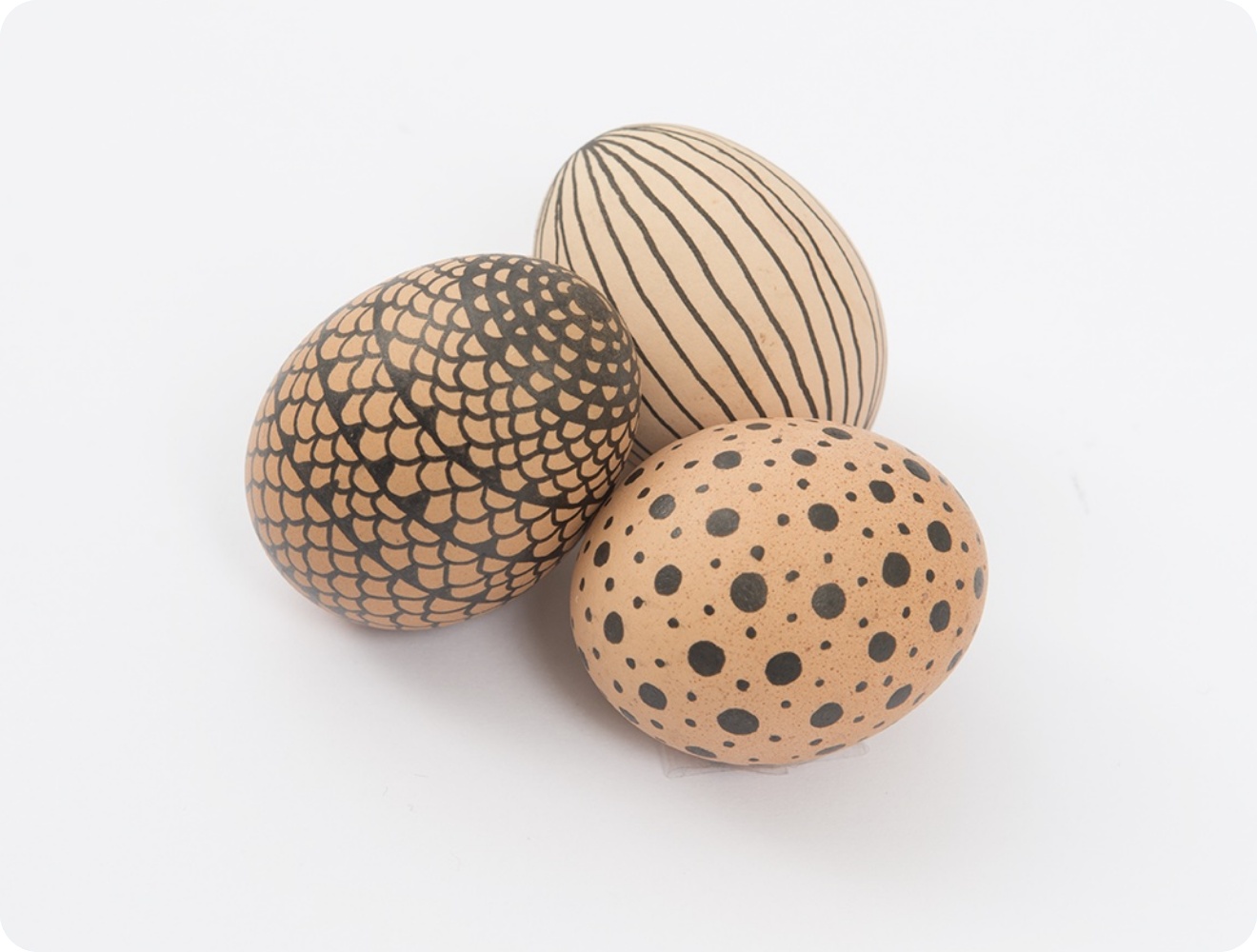 Braune Eier mit grafischen Mustern, die mit einem schwarzen Fineliner aufgetragen wurden.