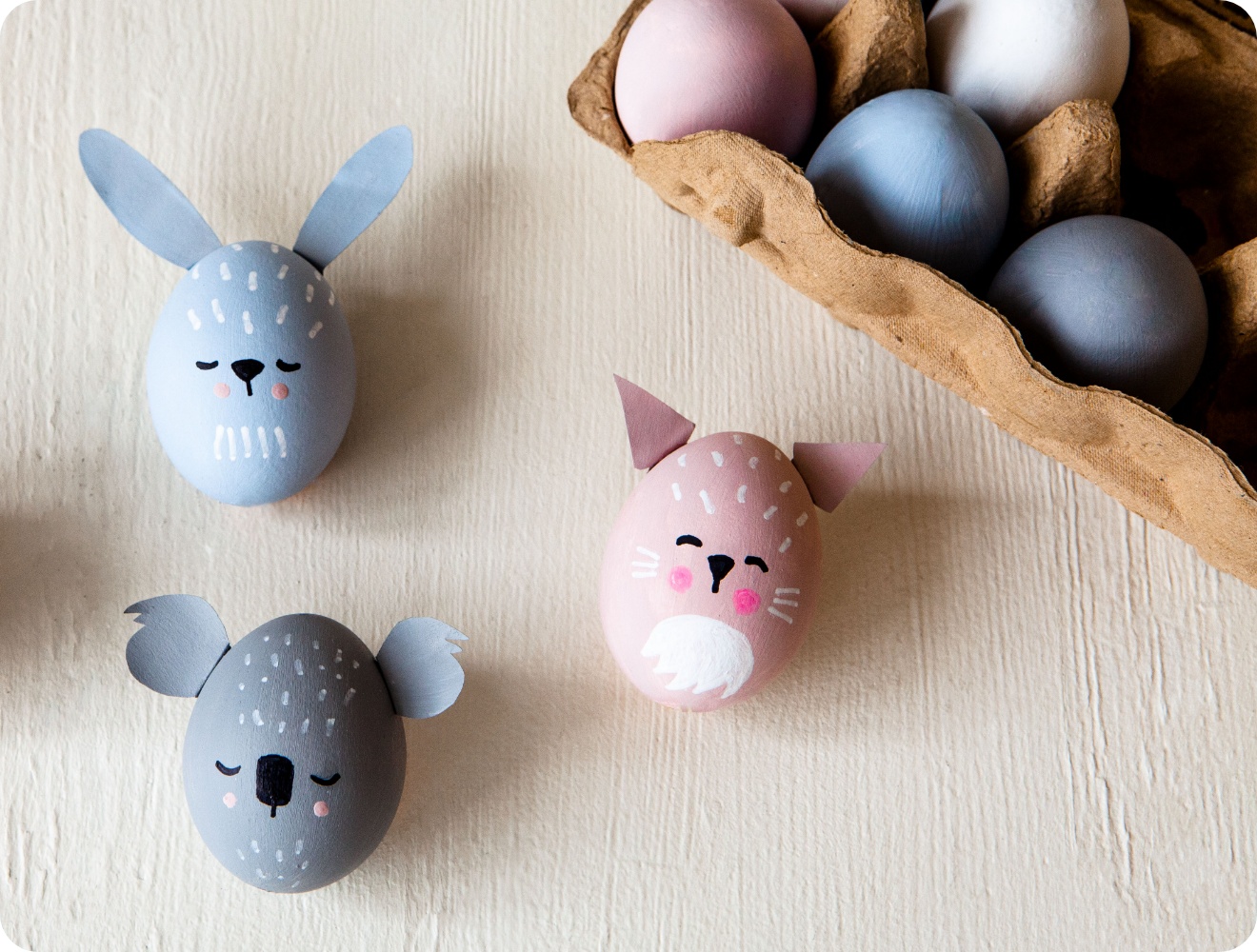 Liebevoll bemalte Ostereier als Tierfiguren. Hase, Koala und Katze mit Ohren aus Papier.