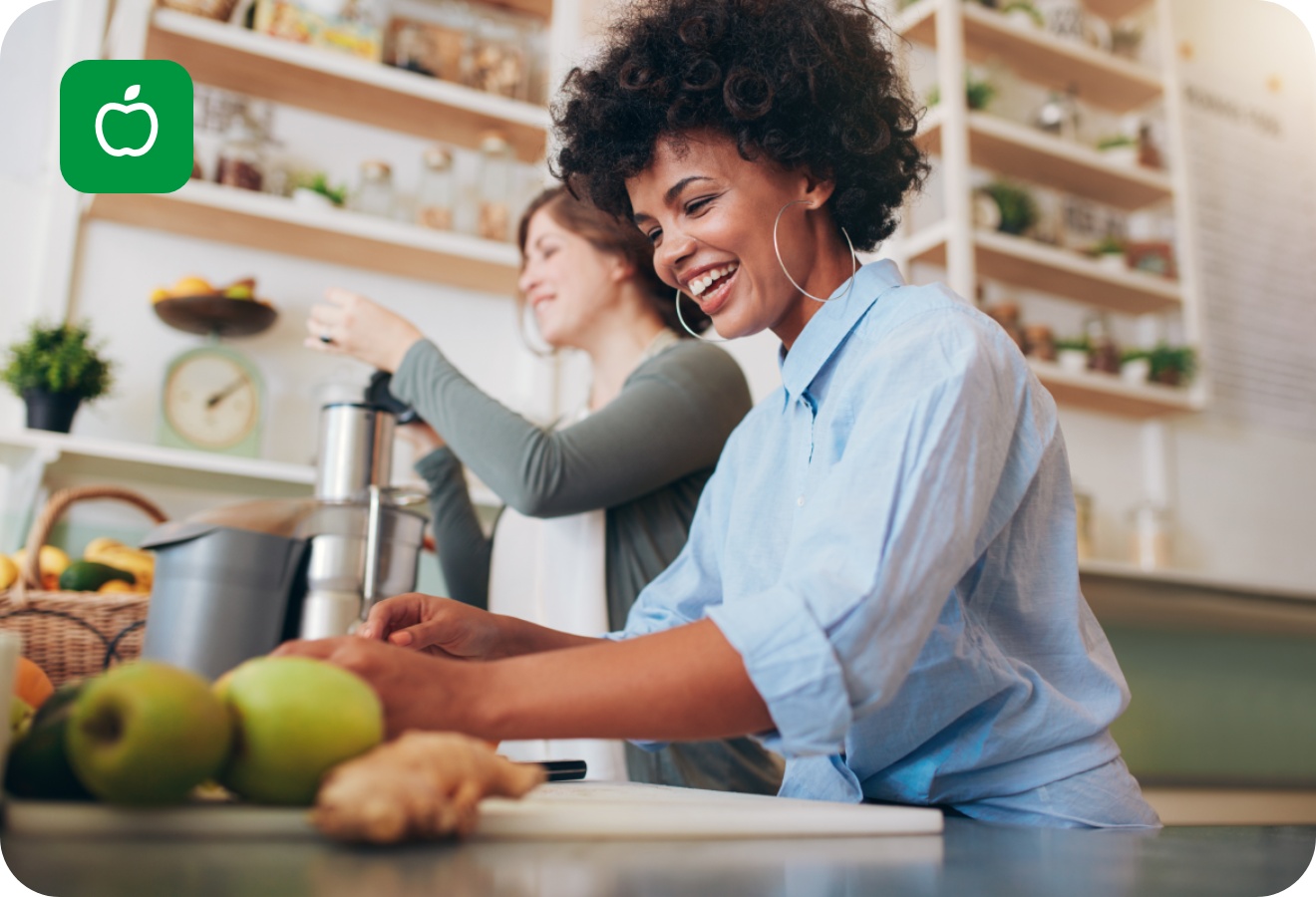 Zwei Frauen entsaften in der Küche Obst und Gemüse für ihre Saftkur.