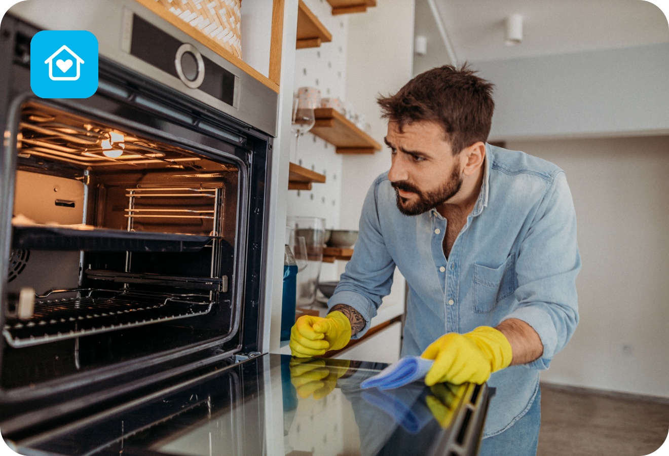 Ein Mann steht mit gelben Haushaltshandschuhen vor dem geöffneten Backofen, um ihn zu reinigen