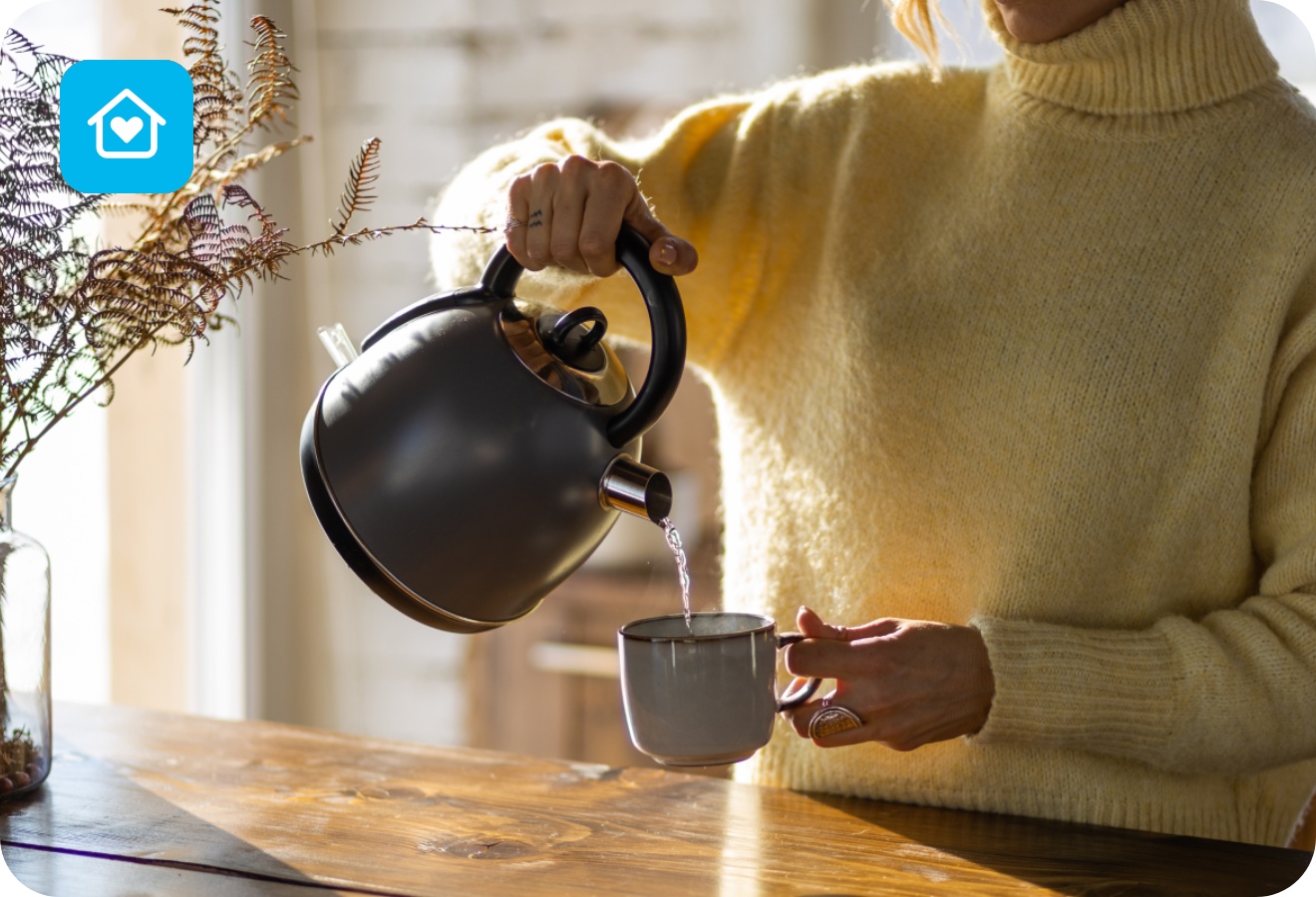 Eine Frau schenkt sich heißes Wasser in eine Tasse.