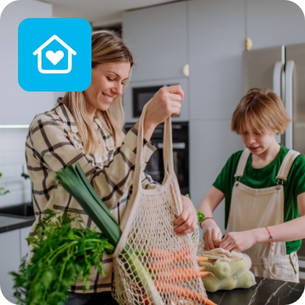 Mutter und Sohn packen Obst und Gemüse das sie eingekauft haben in der Küche aus.