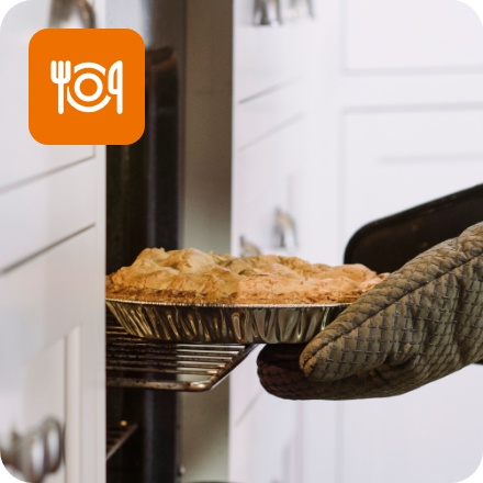 Eine Person holt einen frisch gebackenen glutenfreien Kuchen aus dem Ofen.