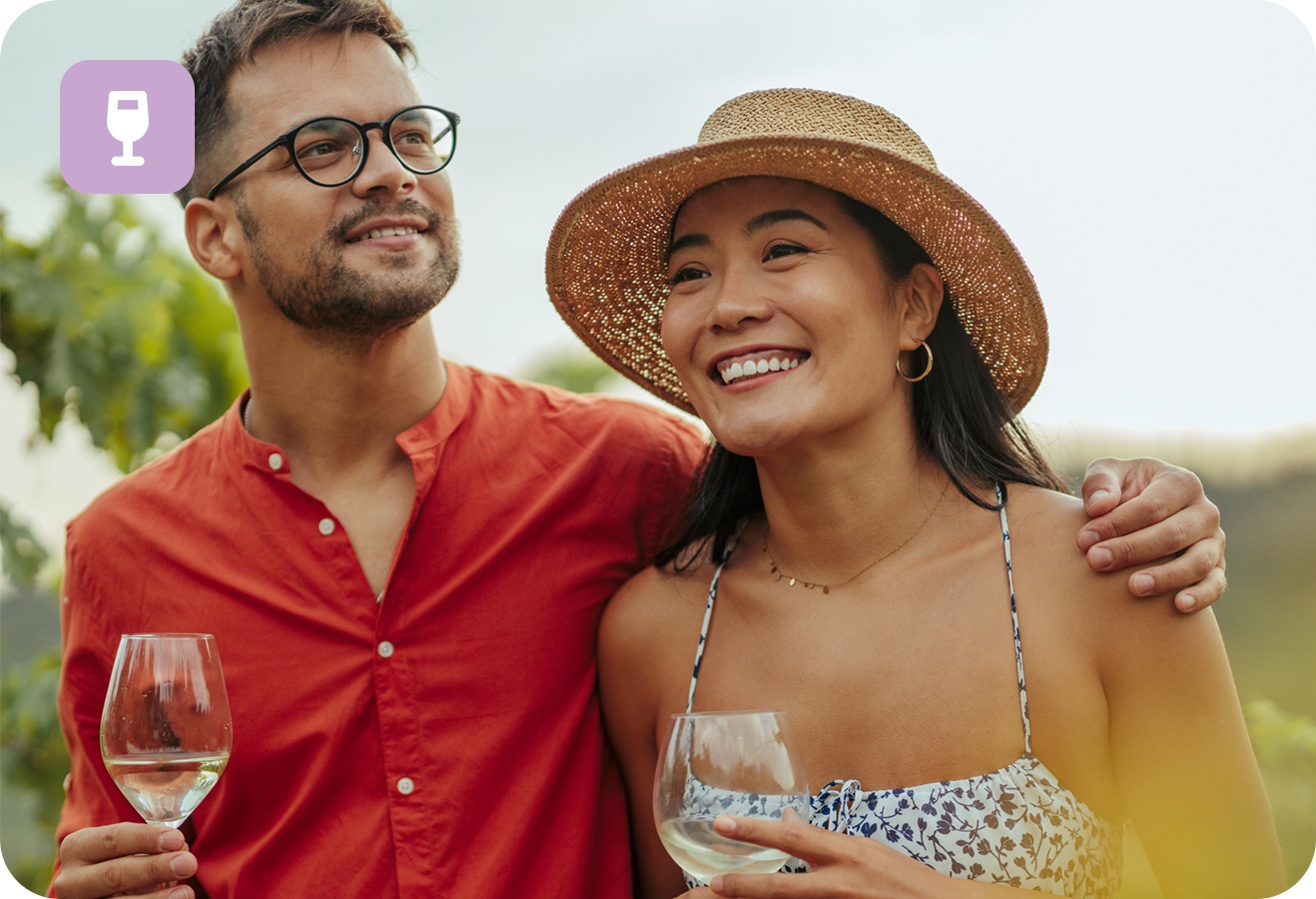 Ein paar mit Weinglas in der Hand steht in den Weinbergen.