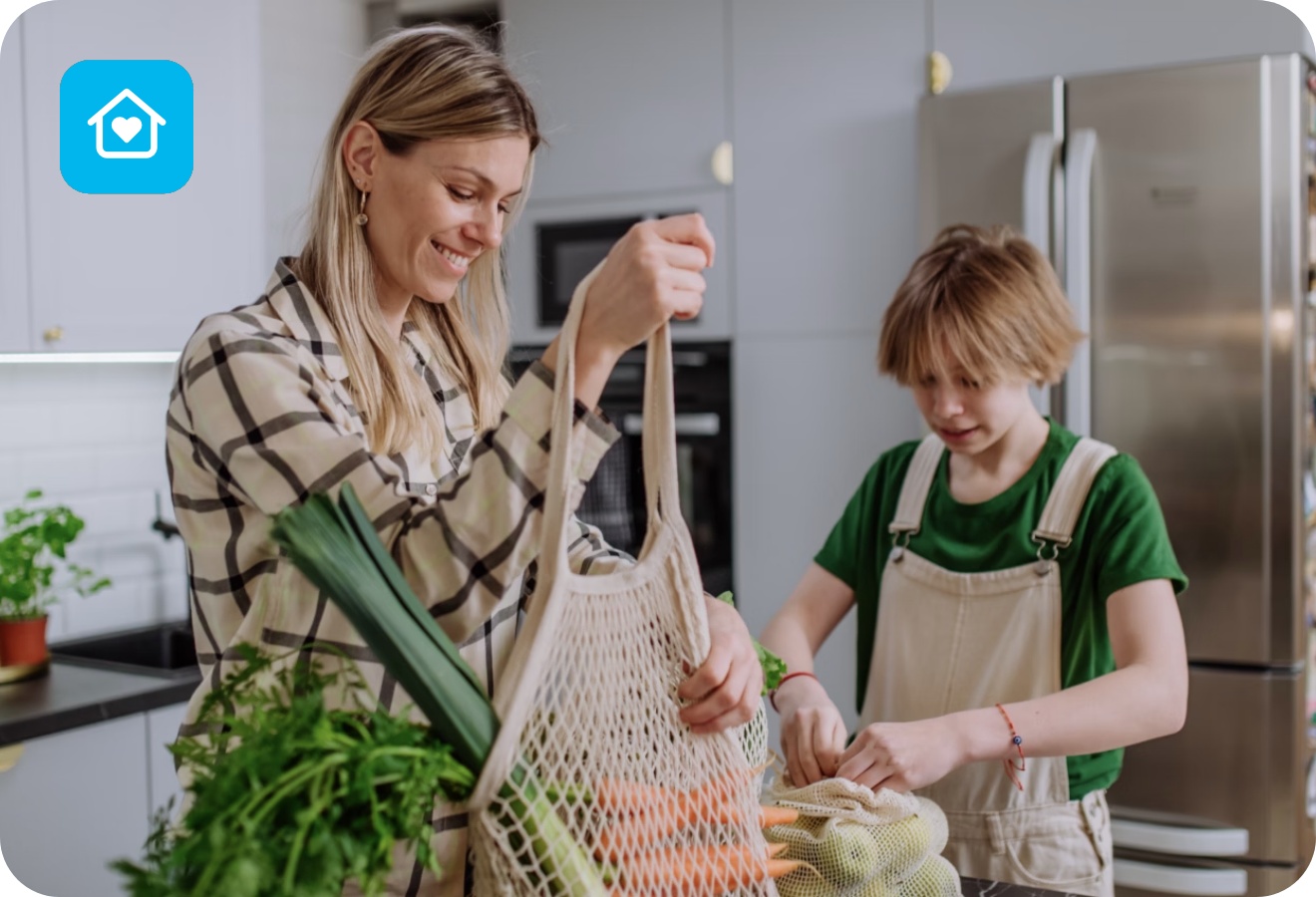 Mutter und Sohn packen Obst und Gemüse das sie eingekauft haben in der Küche aus.