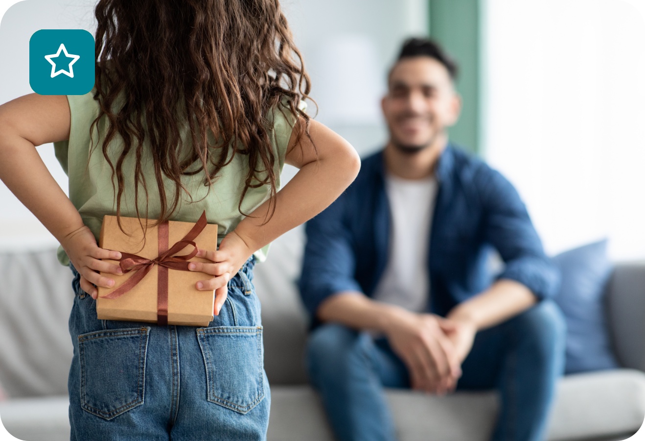 Ein Mädchen versteckt ein selbstgebasteltes Geschenk für ihren Vater hinter dem Rücken.