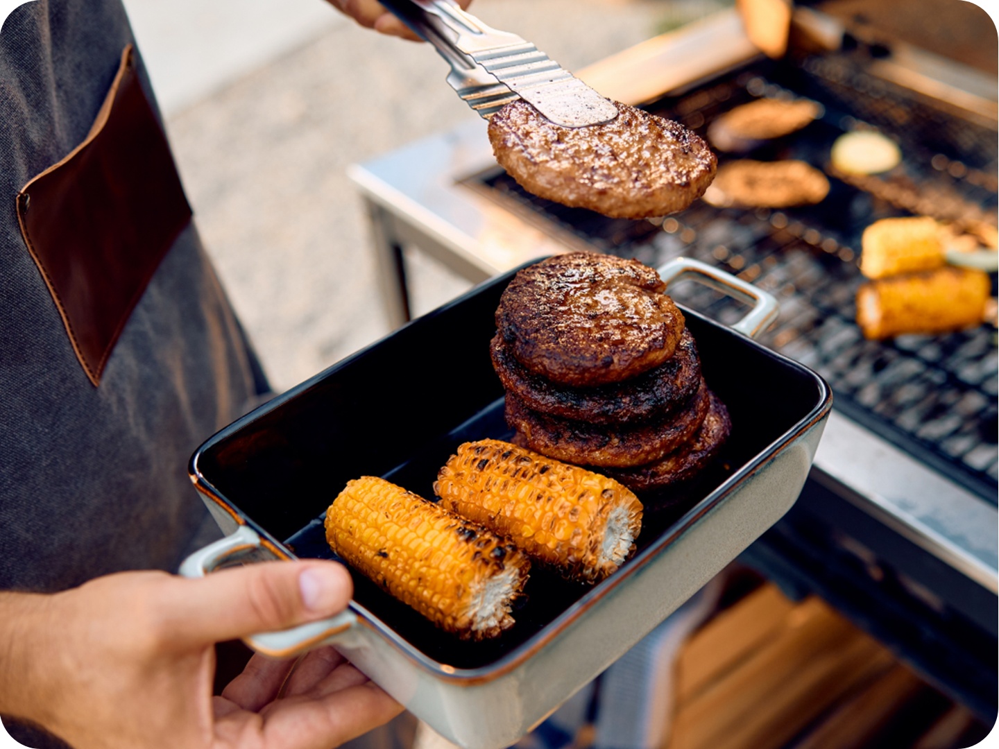 Detailbild eines Grilltellers in der Hand des Grillenden.