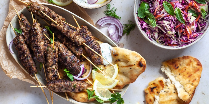 Različna mesna nabodala pečena na žaru in solata v skledi